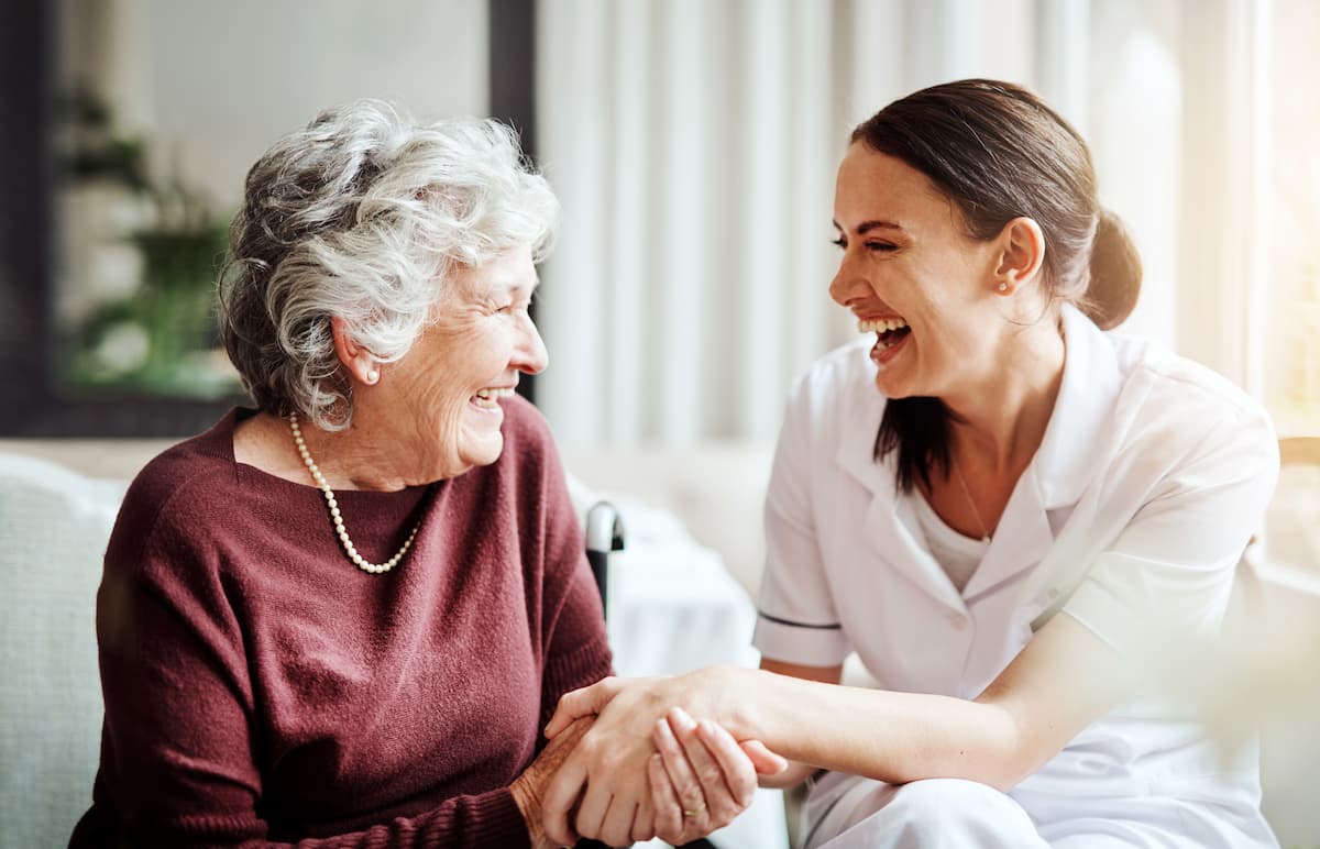 Elderly woman laughing with adult daughter