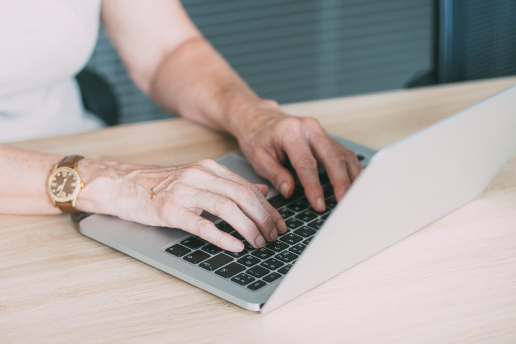 A closeup of a pair of hands typing on a laptop